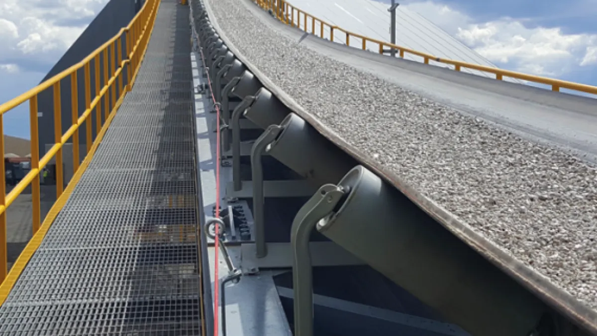 رولیک تعویضی نوار نقاله صنعتی نصب‌شده در زیر تسمه برای حمل مواد معدنی، با طراحی مهندسی‌شده جهت تعویض سریع، کاهش توقف خط تولید و افزایش عمر سیستم نوار نقاله